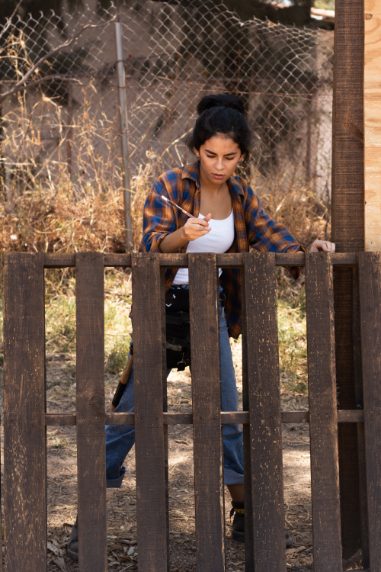 A woman repairing a fence