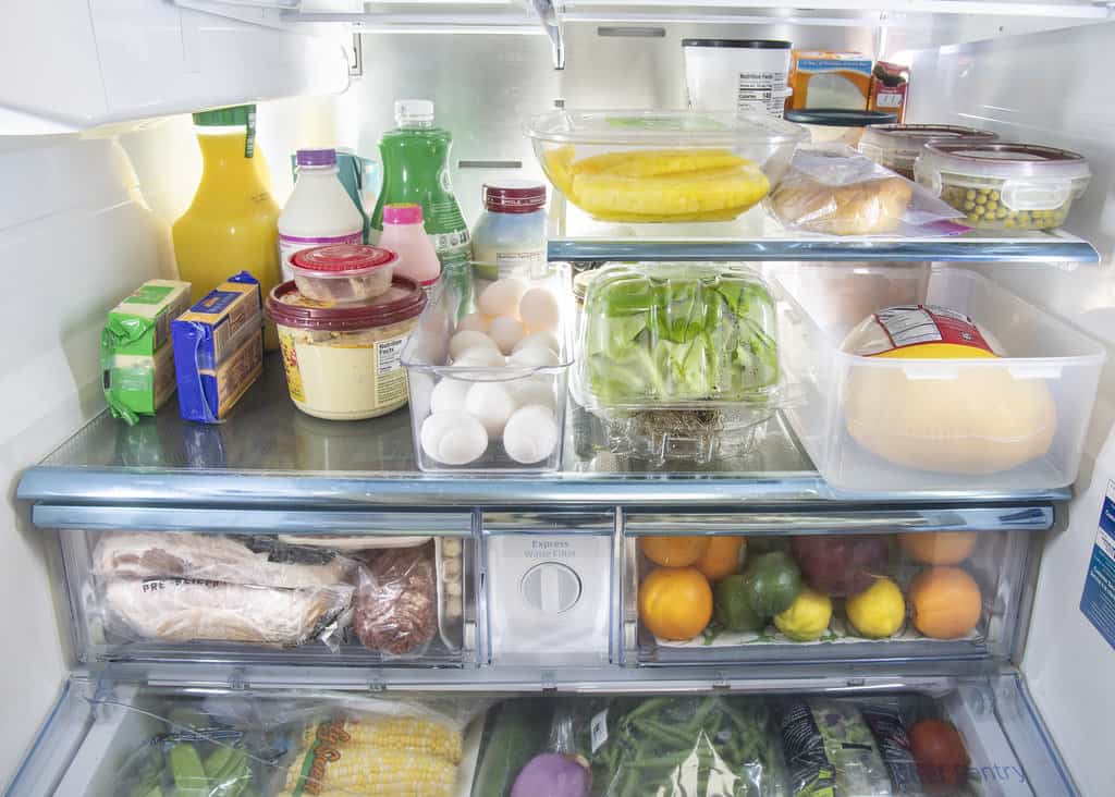 Inside the refrigerator filled with perishables, including eggs, milk, butter, fruits and vegetables.