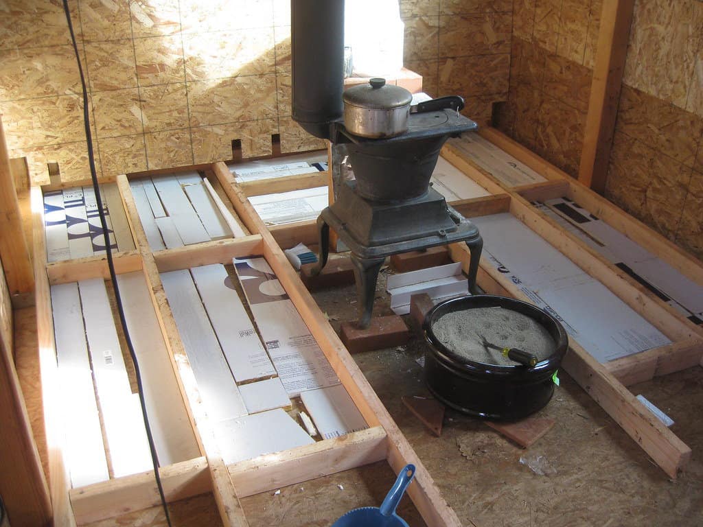 Floor insulation installation in a raised wooden floor.
