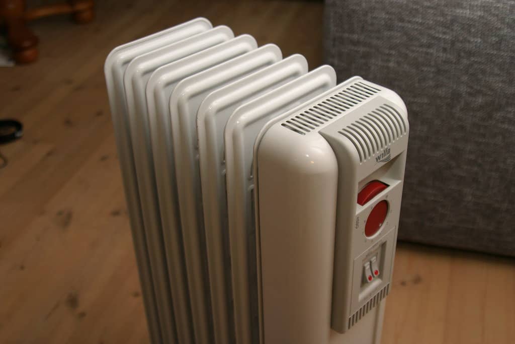 Close-up shot of a white electric oil radiator with visible fins.