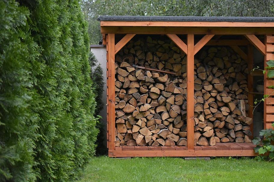 Wooden log house situated at the corner of a garden