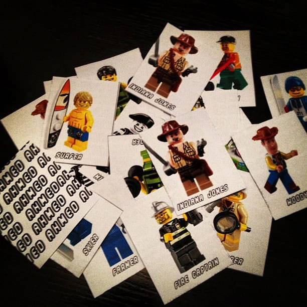 A pile of cards featuring various LEGO minifigures, including Indiana Jones, a surfer, a fire captain, and a farmer.