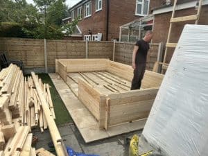 A garden log cabin in the first stages of assembly