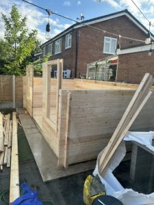 A garden log cabin kit halfway through assembly