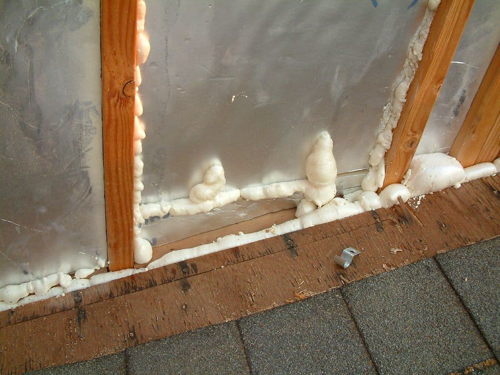 A thin layer of spray foam insulation sealing gaps around a shear wall.