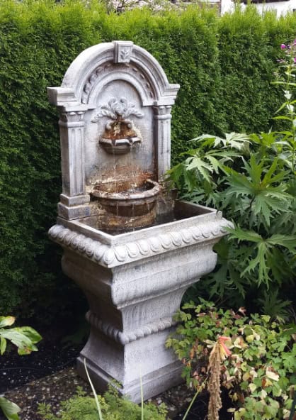 A vintage-style garden fountain with intricate carvings that give it a timeless look.