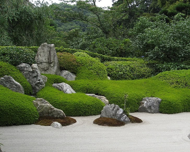 Rock sculptures among garden greenery.