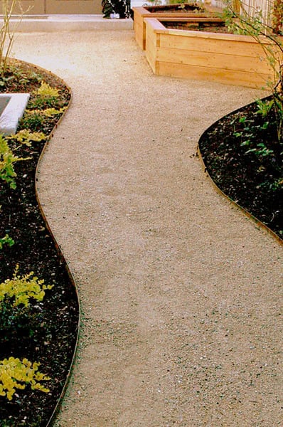 Decomposed granite paths with steel edging, raised beds for veggies, plant installation.