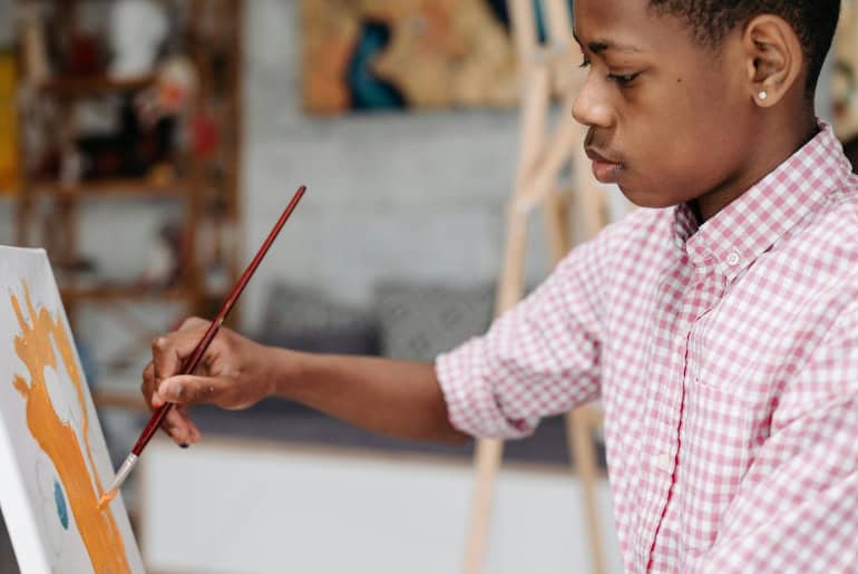 A boy painting on a canvas