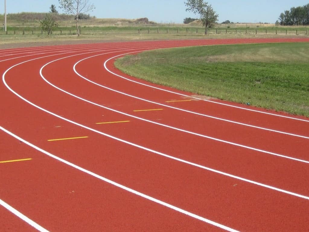 A red running track with white markings on it.