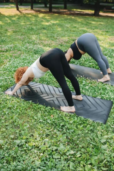 Women doing yoga outdoors.