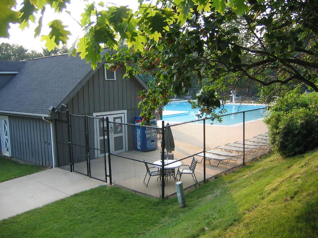 A shed pool house with a swimming pool and sun loungers.