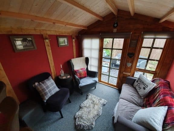 log cabin summerhouse interior with armchairs and sofa