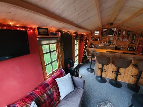 BillyOh log cabin summerhouse interior with Nightjar bar and sofa and stools