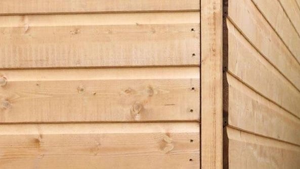 corner of a shiplap tongue and groove timber shed with nails near corner join