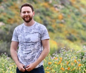 Jack Wallington stood in a field of flowers