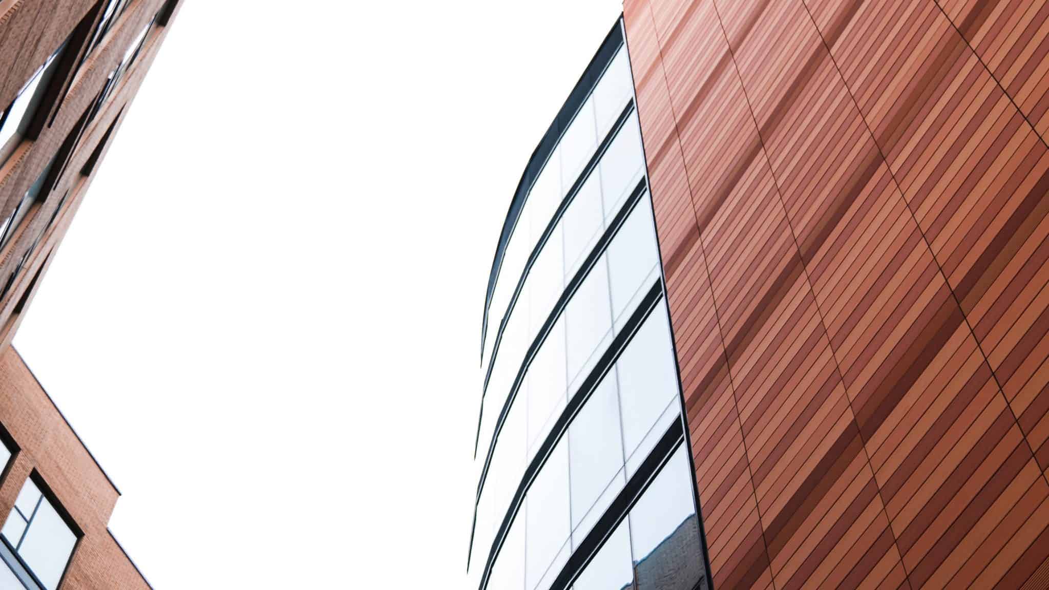 large building with exterior wooden slats and rows of windows curving round