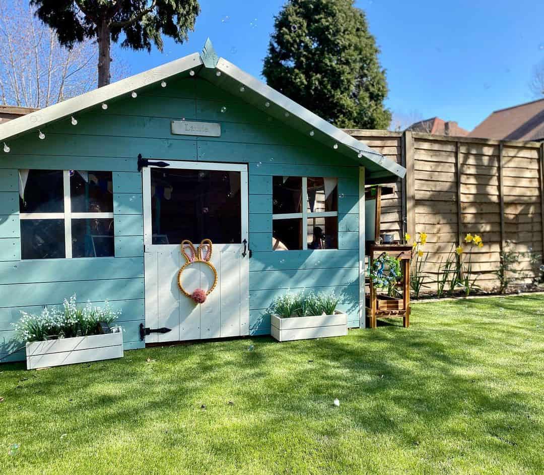 pent roof single storey playhouse on grass painted blue and white