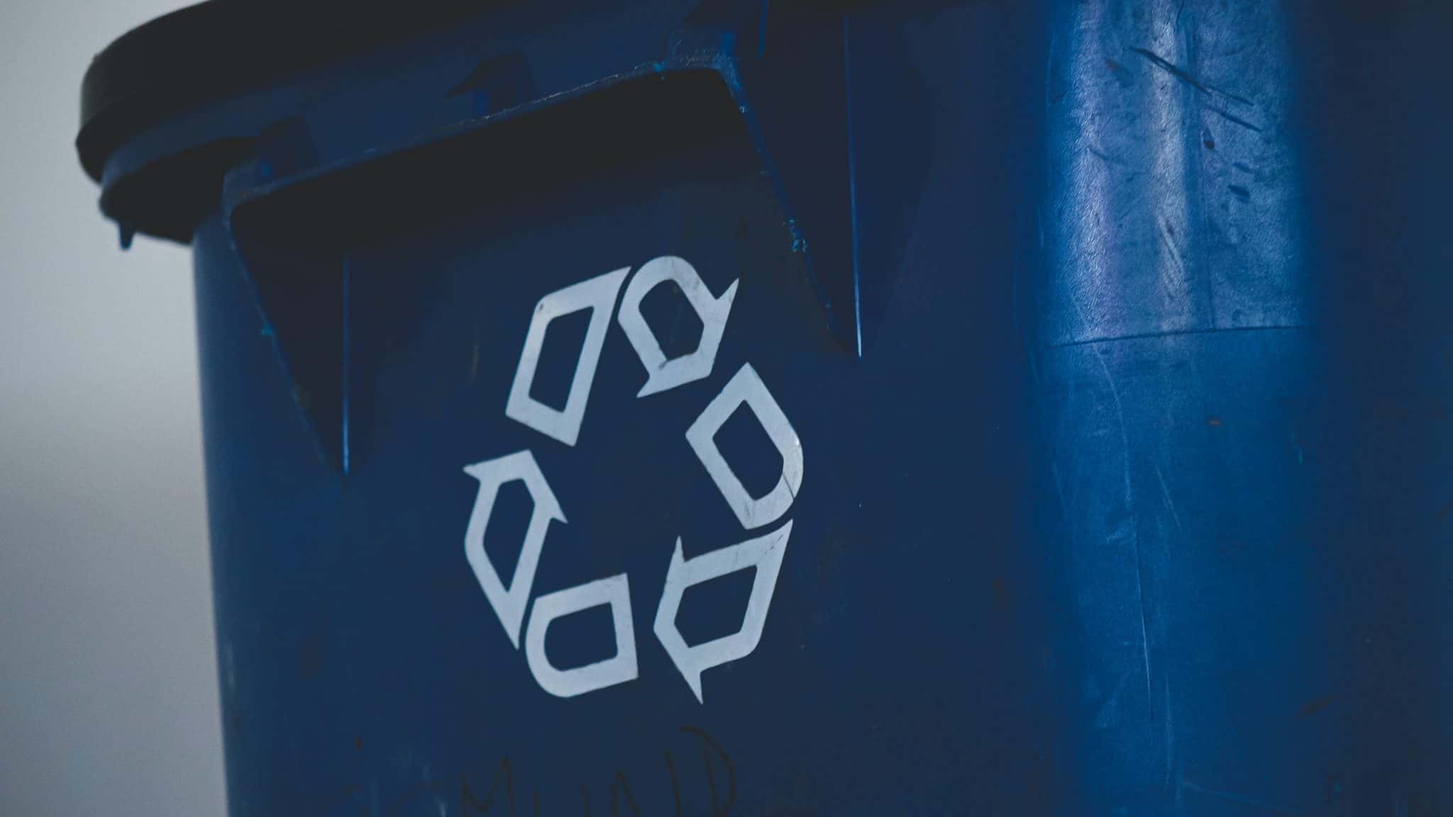 Blue recycling bin focused on recycle logo